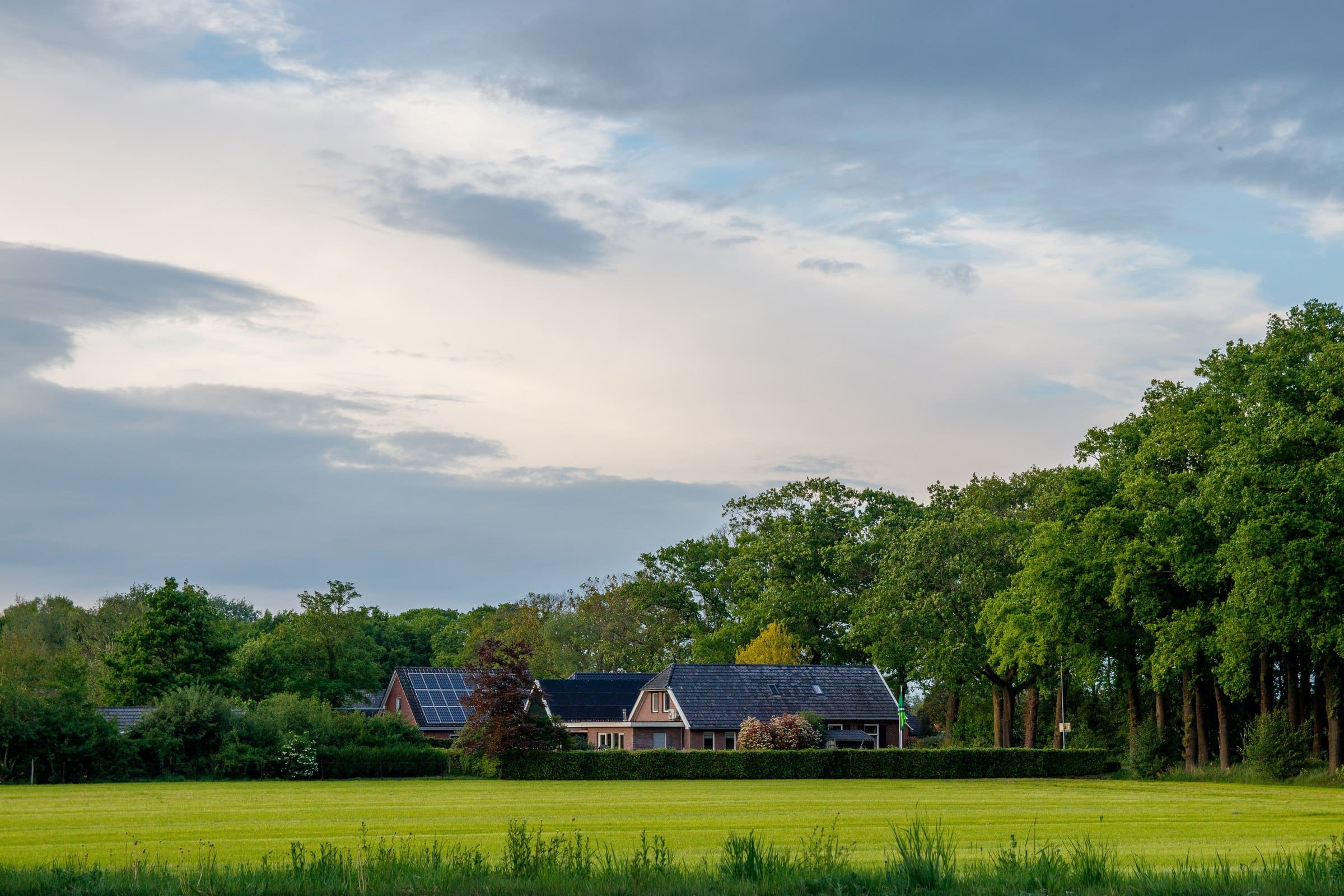 A bungalow with a panelled roof across an evening field