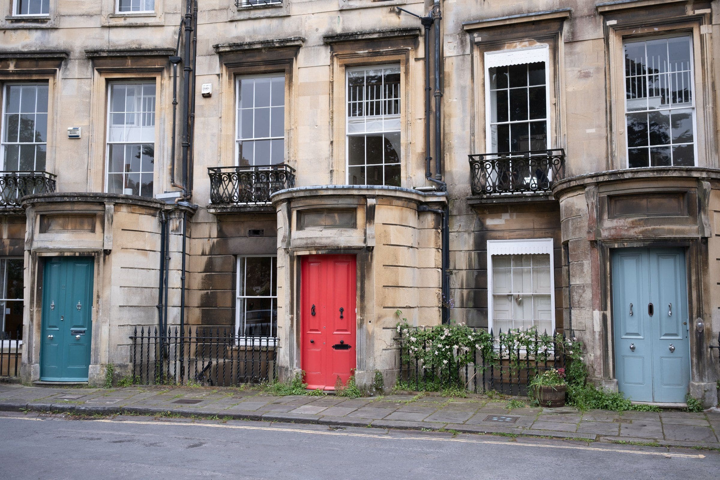 Georgian stone houses with red, teal and blue front doors