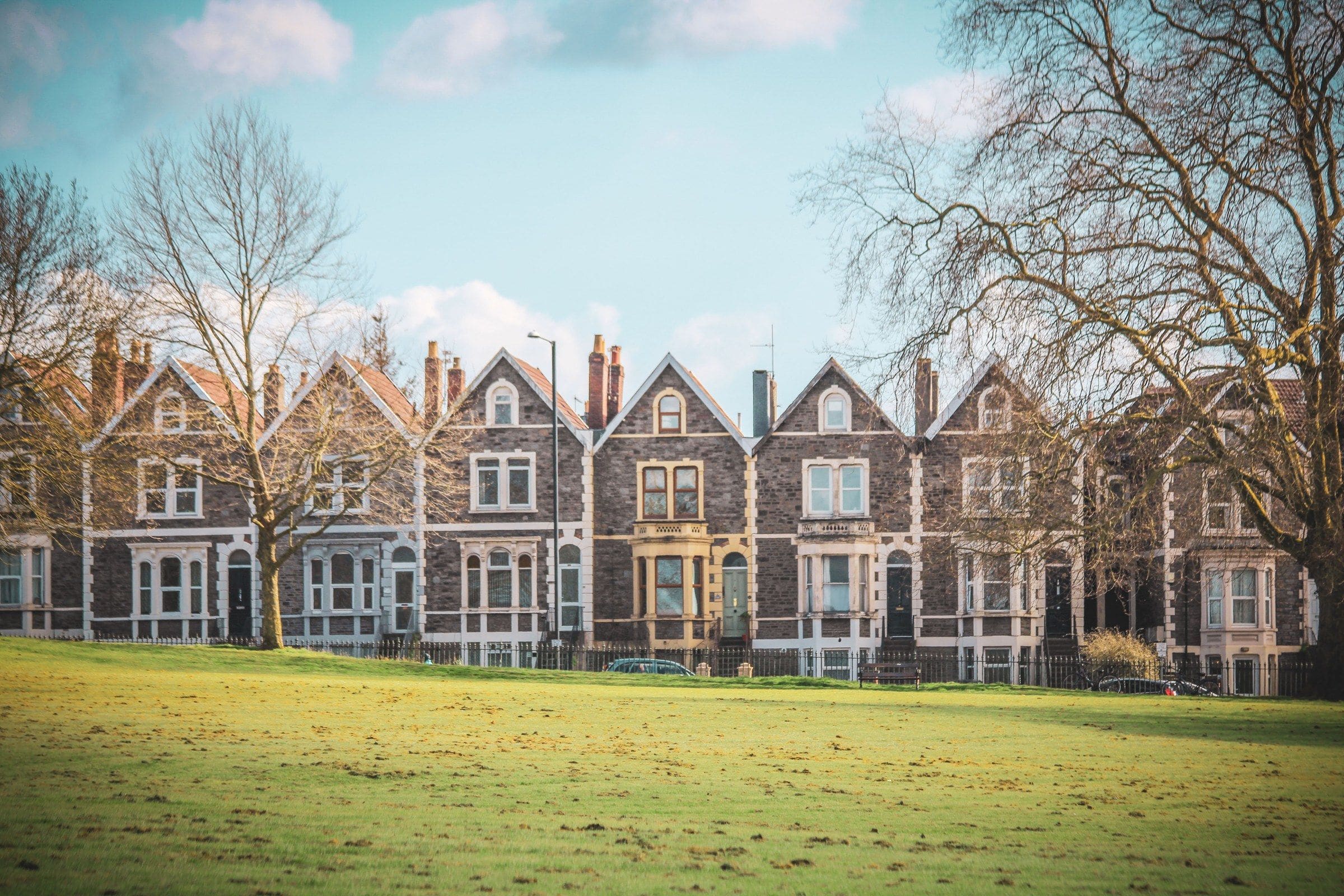 A row of Victorian terraced houses facing a park