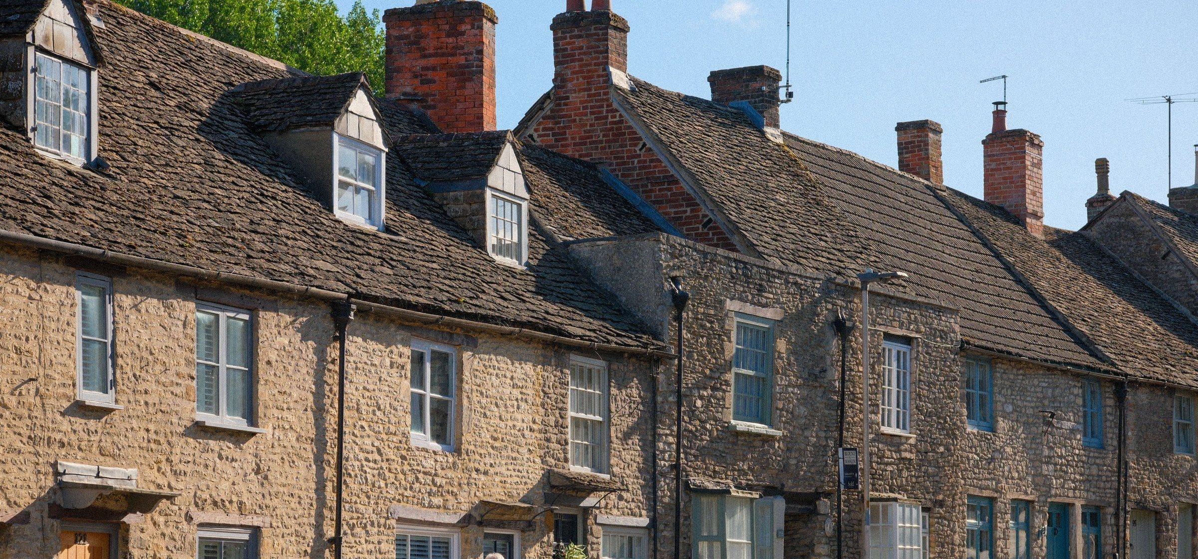 Stone cottages with stone-tiled roofs and dormer windows along a village street