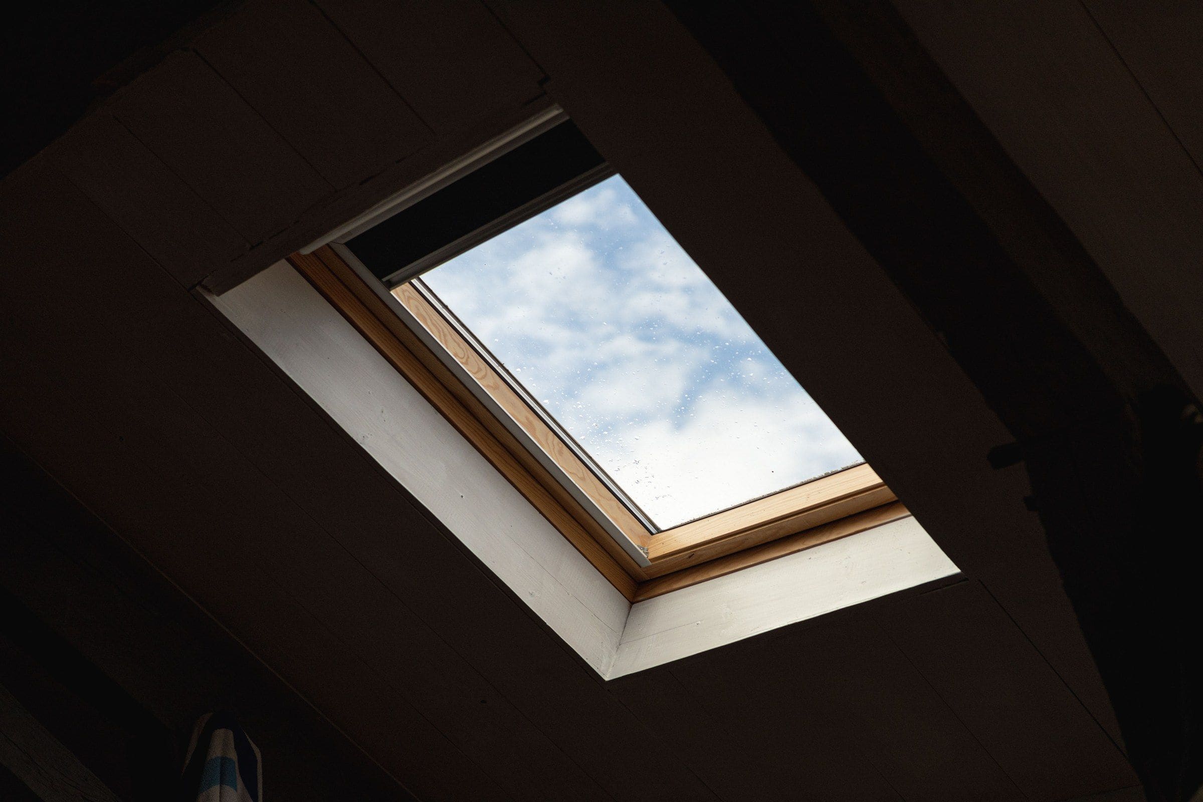 A roof window in a dark loft, seen from inside