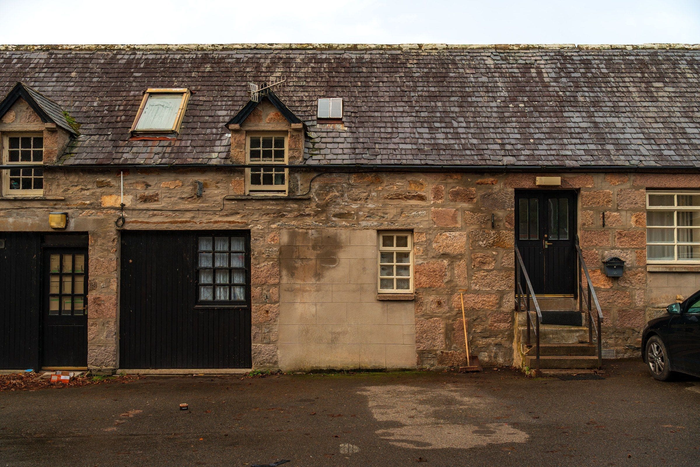 A natural slate roof on a row of granite cottages, with dormers and roof windows